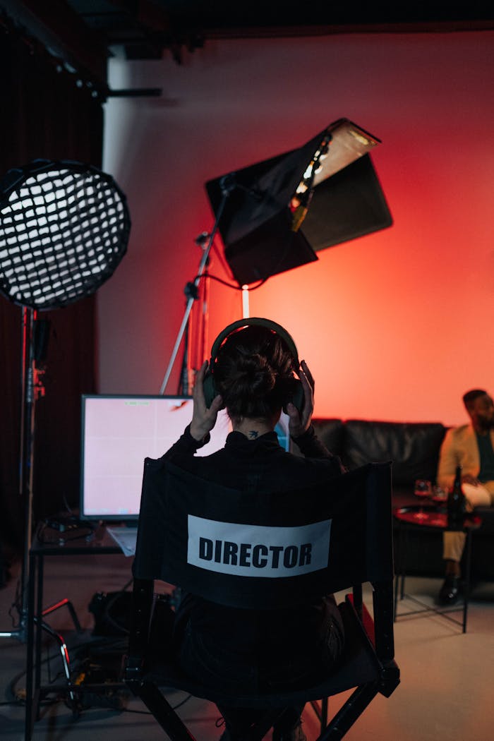 Film director in chair with headphones in a studio setting.